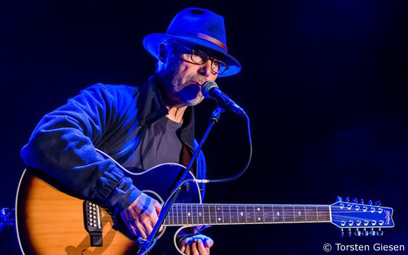 Hugh Featherstone on stage with his trusty Washburn 12-string guitar